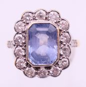 An unmarked gold, diamond and blue stone ring. Ring size P.