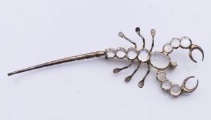 A moonstone scorpion brooch. 8 cm long.
