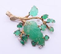 A 14 K gold, diamond and emerald leaf brooch/pendant. 5.5 cm high. 16.1 grammes total weight.
