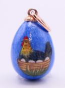 A 14 ct gold and enamel chicken and egg pendant. 2 cm high.