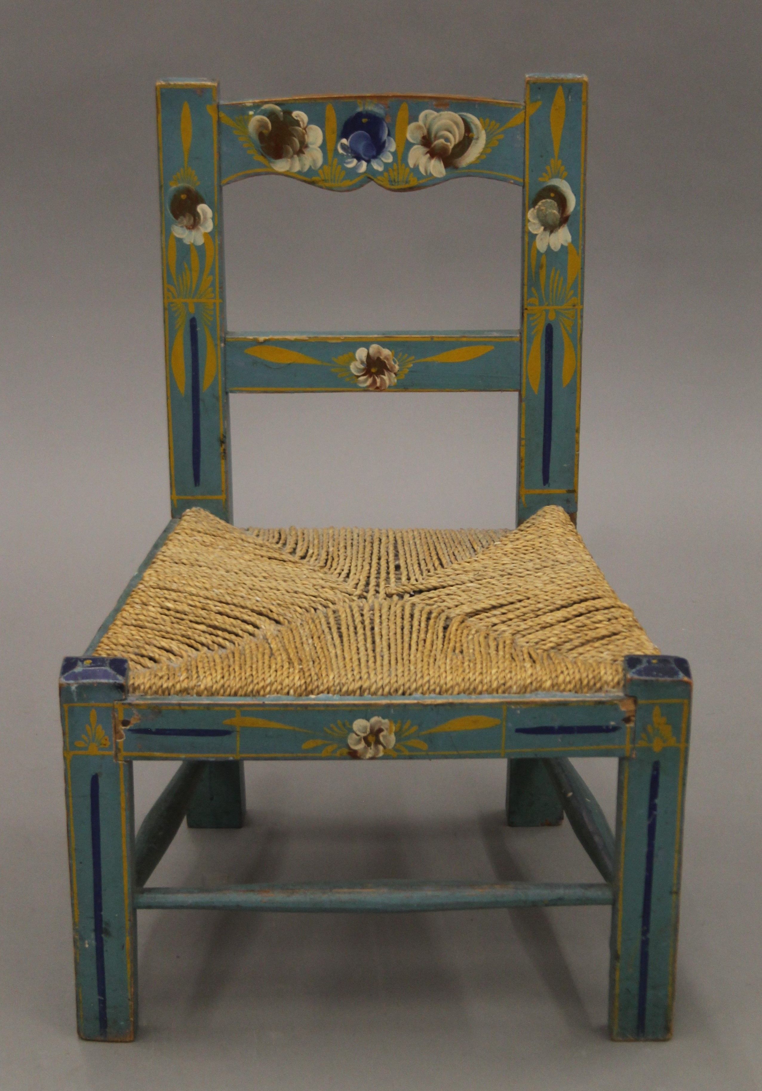 A florally-painted child's chair. 43 cm wide.