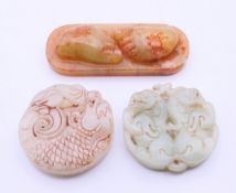 Three jade roundels. Two 5.25 cm diameter, the other 8.5 cm long.