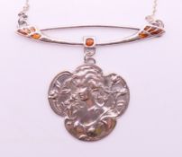 A silver Art Nouveau style female amongst flowers pendant necklace.