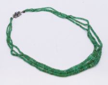 A three-strand emerald graduated bead necklace. 50 cm long.
