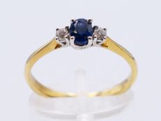 An 18 ct gold diamond and sapphire three stone ring. Ring size P. 2.3 grammes total weight.