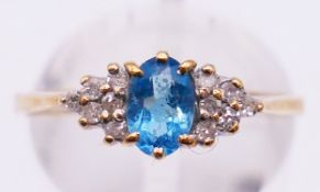 A 9 ct gold diamond ring centred with a blue stone. Ring size P/Q. 1.9 grammes total weight.