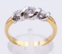 An 18 ct gold three stone diamond ring. Ring size P/Q. 4.4 grammes total weight.