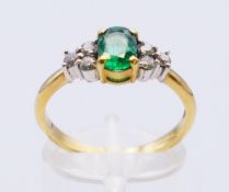 An 18 ct gold, diamond and emerald ring. Ring size Q. 3.5 grammes total weight.