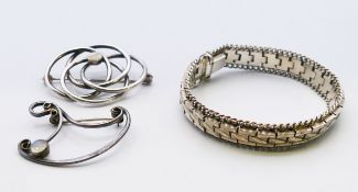 Two silver brooches and a bracelet. Bracelet 18 cm long. 1.25 cm high.