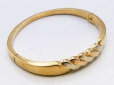 A 14 K gold bangle bracelet. 6.5 cm external diameter, 1 cm high at highest point. 18 grammes.