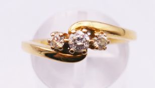An 18 ct gold three stone diamond ring, marked 0.25 carat. Ring size Q. 4.1 grammes total weight.
