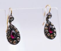 A pair of old cut diamond drop earrings, centred with a red stone cabochon, in a Bravingtons box.