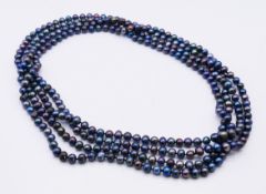 A black pearl necklace, in a Mille Perle black pouch.