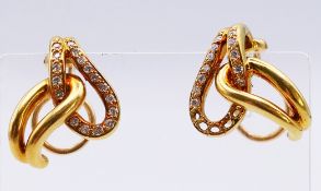 A pair of unmarked gold and diamond earrings (some diamonds missing to one earring). 2 cm high. 11.