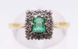 An 18 ct gold diamond and emerald ring. Ring size P/Q. 3.8 grammes total weight.