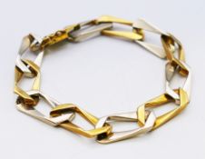 An alternating 18ct white and yellow gold curb link bracelet. 19 cm long. 27 grammes.