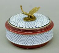 A porcelain lidded box with gilt metal dragonfly finial. 14 cm diameter.
