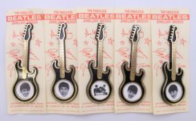 A set of five 1968 Beatles guitar-shaped brooches featuring photos of Paul McCartney, John Lennon,