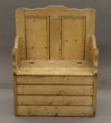 A pine box settle with hinged seat. 74 cm wide.