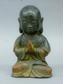 A Chinese bronze of a praying boy. 19 cm high.