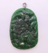 A Chinese silver-topped green jade dog-of-fo pendant. 6.25 cm high.