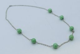 A platinum seed pearl and jade bead necklace. 43 cm long.