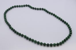 A green jade bead necklace. 80 cm long.
