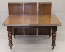 A 20th century mahogany three-leaf extending dining table and an early 20th century mahogany