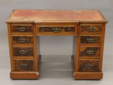 A Victorian leather-topped walnut desk. 122 cm wide.