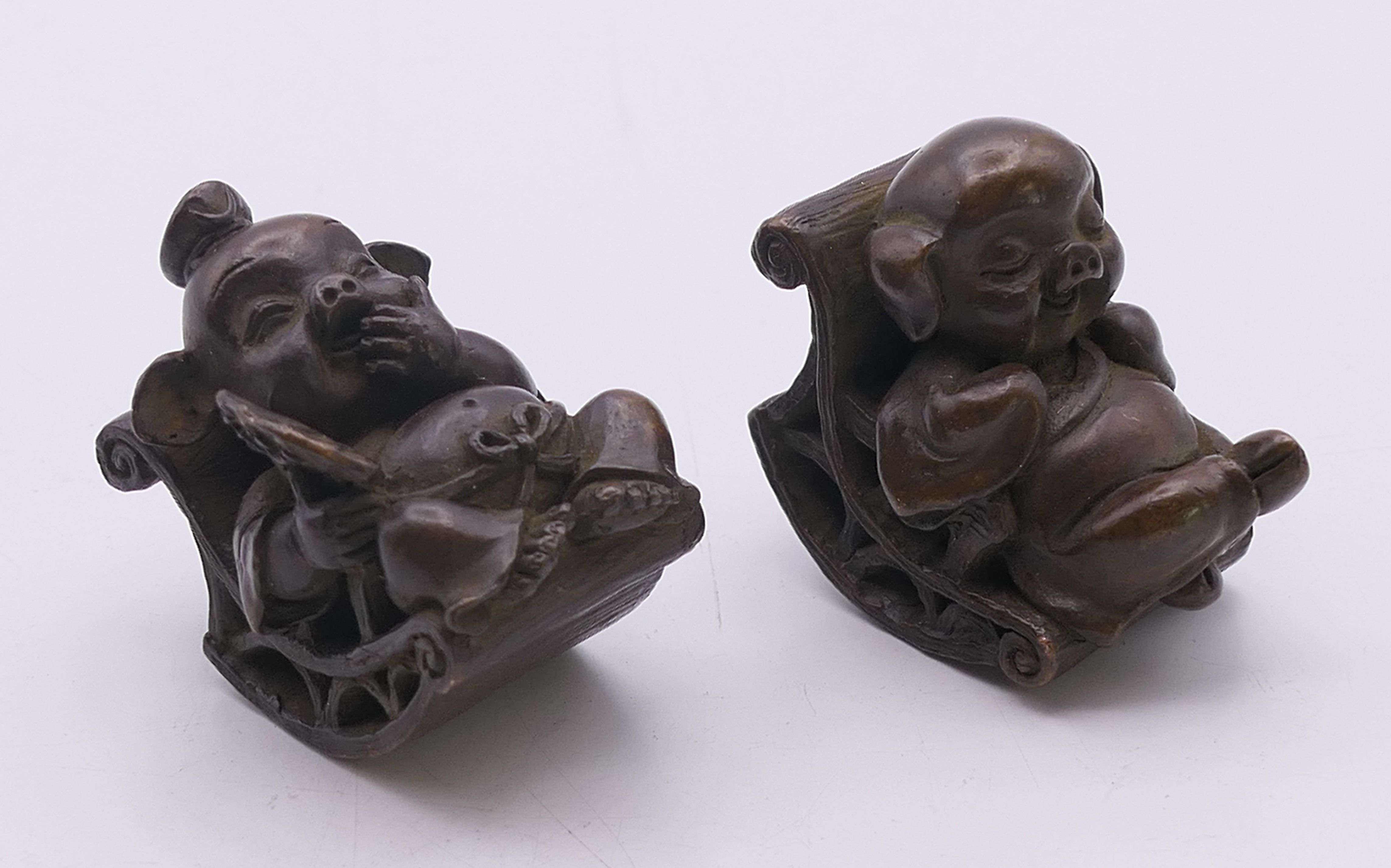 A pair of bronze seated pigs. Larger 4.5 cm high.