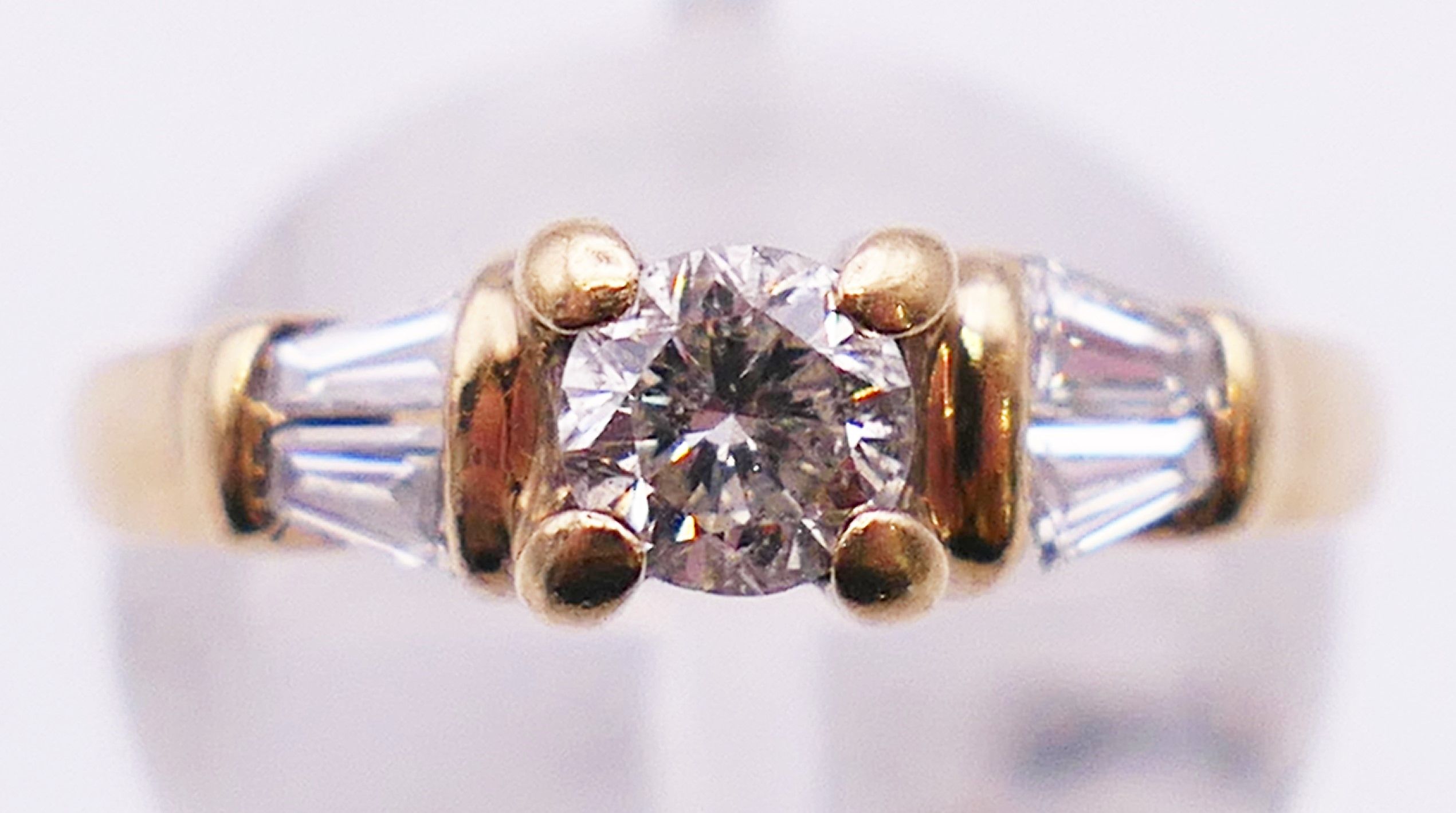 A 9 ct gold diamond solitaire with trapeze cut diamond shoulders. 3.8 grammes. Ring size L. - Image 2 of 5