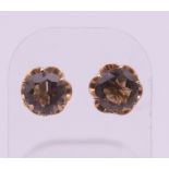 A pair of 14 ct gold and smoky quartz ear studs. 1 cm diameter. 2.5 grammes total weight.