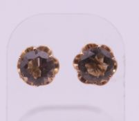 A pair of 14 ct gold and smoky quartz ear studs. 1 cm diameter. 2.5 grammes total weight.