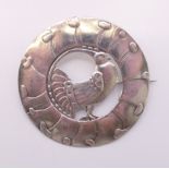 A pewter peacock brooch. 6.75 cm diameter.
