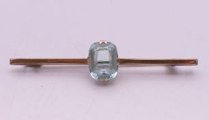 A 9 ct gold and aquamarine bar brooch, in a J Chaumet box. 5.5 cm long.