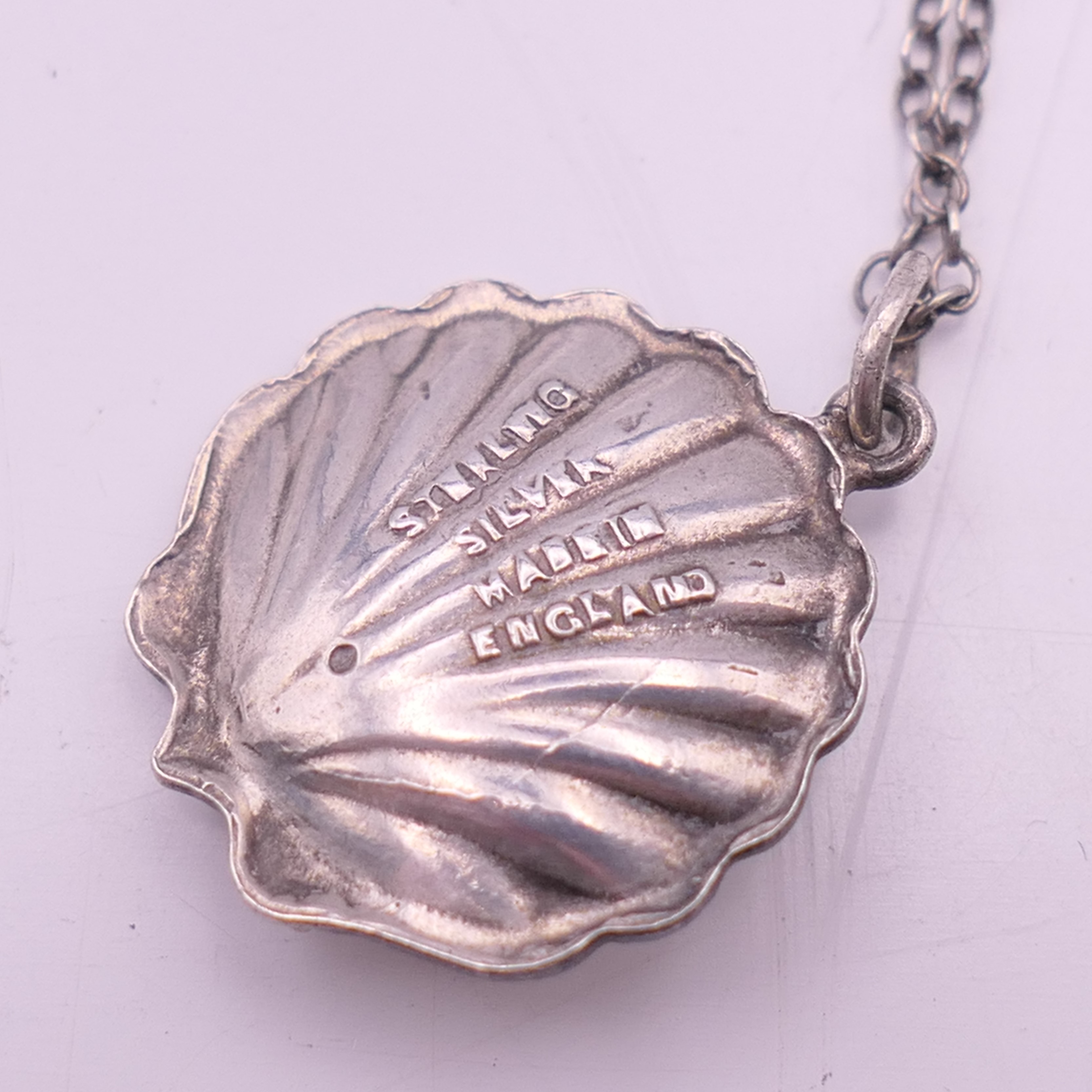 A silver and enamel pixie in a shell pendant on a silver chain. Pendant 2 cm high, chain 46 cm long. - Image 4 of 6