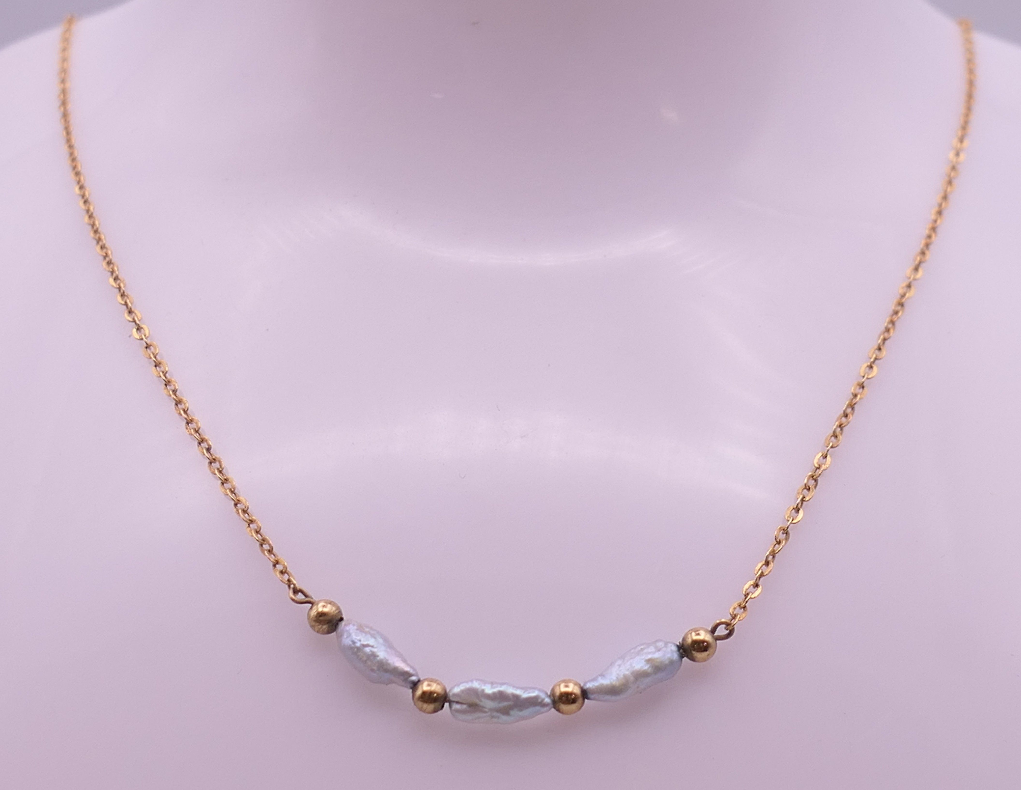 A 9 ct gold and pearl necklace. Approximately 40 cm long. 1.7 grammes total weight.