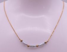 A 9 ct gold and pearl necklace. Approximately 40 cm long. 1.7 grammes total weight.