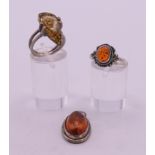 Two silver and amber rings and an amber pendant. Pendant 2.5 cm high.