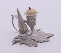 A small silver leaf shaped chamberstick and snuffer. 5 cm high.