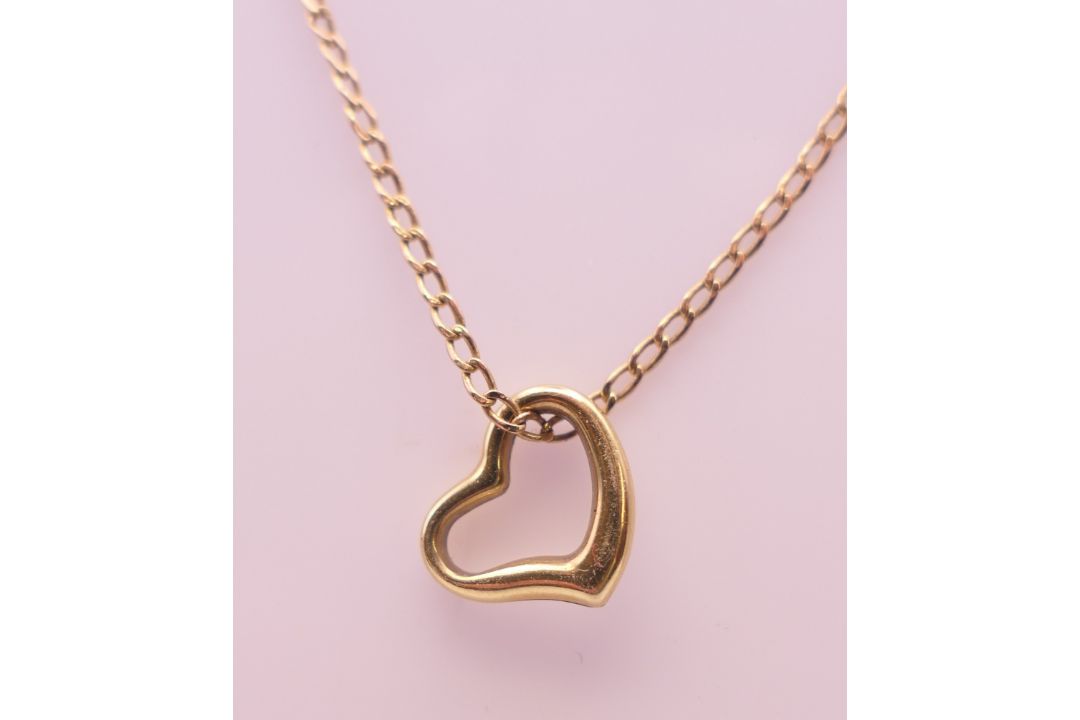 A 9 ct gold heart shaped pendant on a 9 ct gold fine chain. Pendant 1 cm x 1 cm, chain 42 cm long. - Image 2 of 9