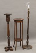 A carved oak torchere, a mahogany torchere and a standard lamp. The former 113.5 cm high.