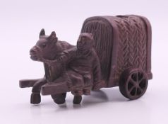 A model of a man with an ox pulling a cart. 8.5 cm long, 5 cm high.