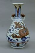 A Chinese blue and red porcelain vase decorated with dragons. 35 cm high.
