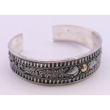 An 18 K gold on silver bangle. 1.5 cm high.