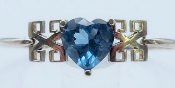 A silver bangle with heart shaped blue stone. Heart 1.5 cm high.