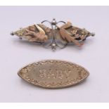Two Victorian silver brooches, one inscribed 'BABY', the other with a swallow and floral design.