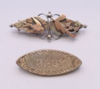 Two Victorian silver brooches, one inscribed 'BABY', the other with a swallow and floral design.
