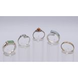 Four silver rings and a ring marked 375. The later ring size R.