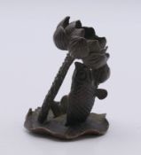 A model of a fish on a lily pad. 5.5 cm high.